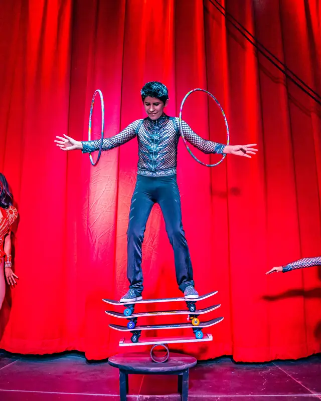 Performer balancing on skateboards with two hoops